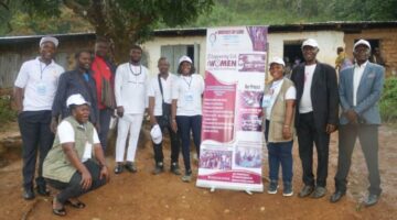 The Fon of Aletening village in complete white wearing a black  traditional cap and beats amidst BGG staffs at a project  implementation